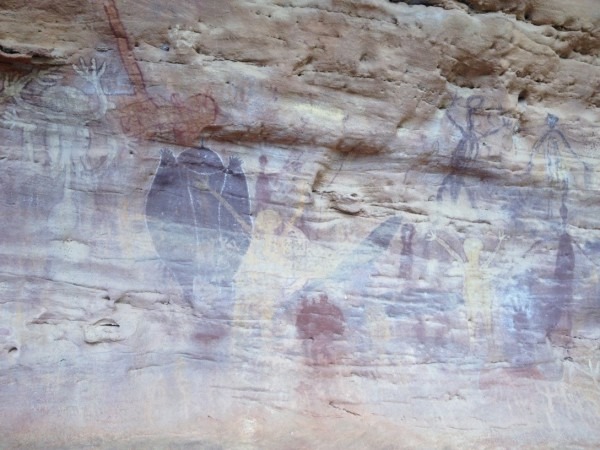 Spirit figures (Quinkans). Bent arms and knobbed penis on the white figure on left suggests it has a spiteful nature.  Dark figure to its right represents an echidna (spiny anteater), an egg-laying mammal related to the platypus.  Photo by Paul Ehrlich and Chris Turnbull